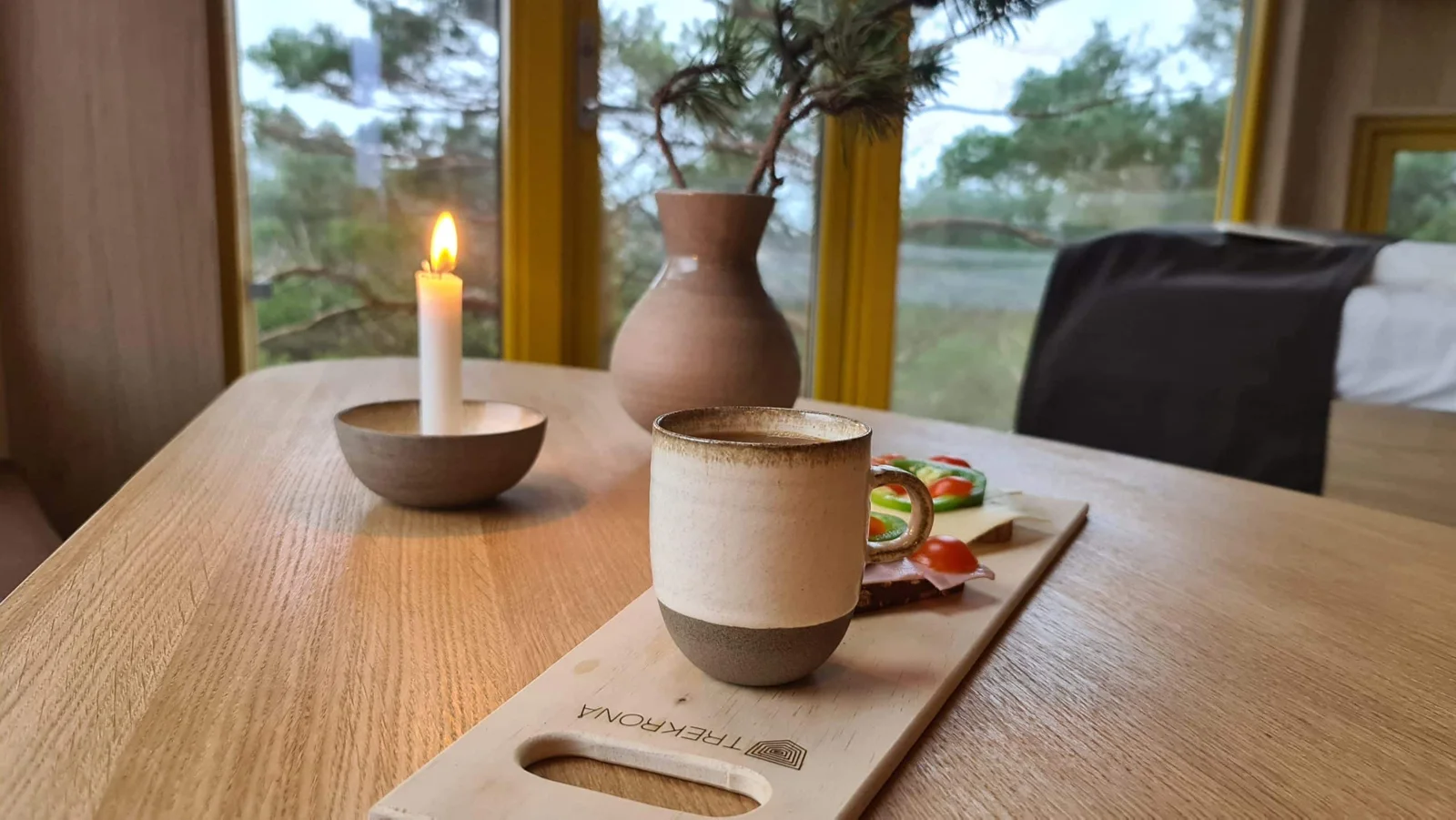 Morgenkaffe ved vinduet med utsikt mot furuskogen